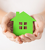 Manos de la mujer que sostienen la casa verde | Foto de stock