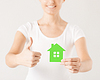 Manos de la mujer que sostienen la casa verde | Foto de stock