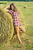 Muchacha en la paja fresca | Foto de stock