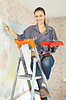 Happy woman paints wall | Stock Foto