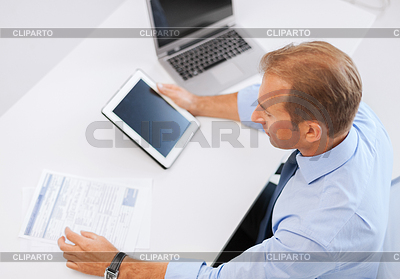 Businessman with tablet pc and papers in office | High resolution stock photo |ID 3936731