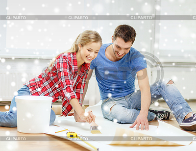 Smiling couple smearing wallpaper with glue | High resolution stock photo |ID 4639524